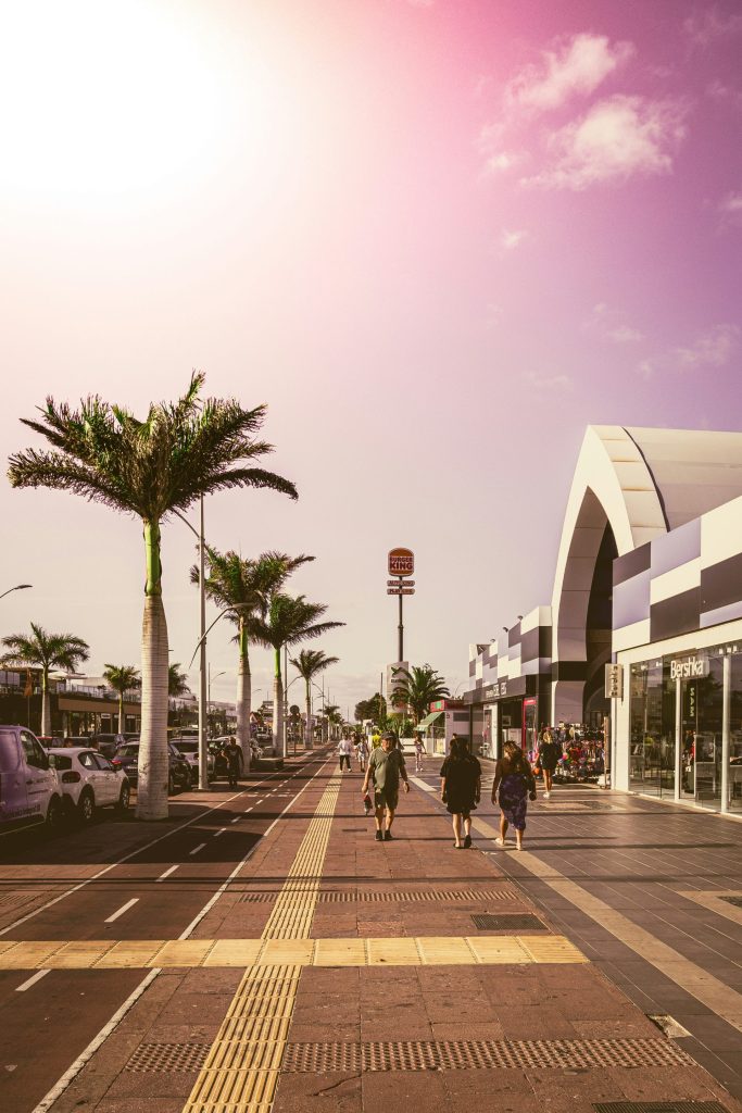People walking down the sidewalk of a shopping center